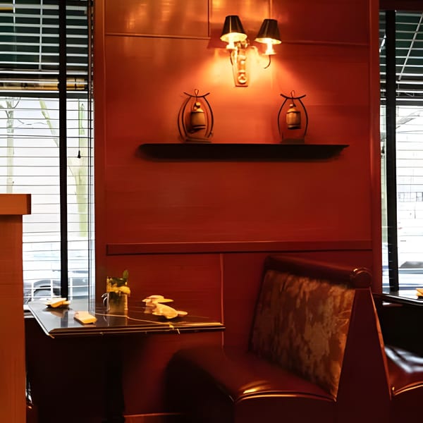 Cozy booth seating with warm lighting, decorative lanterns, and a table set for dining at Asiana Cafe.