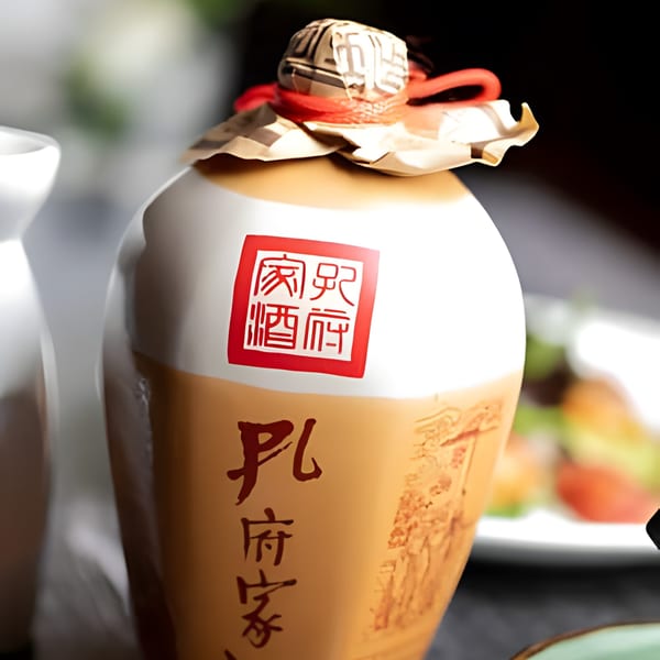 A traditional Asian-style ceramic liquor bottle with red and black calligraphy, next to a white sake carafe.