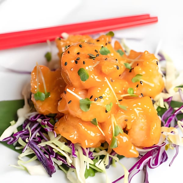 Asiana Cafe's orange shrimp with black sesame seeds, microgreens, and shredded cabbage.
