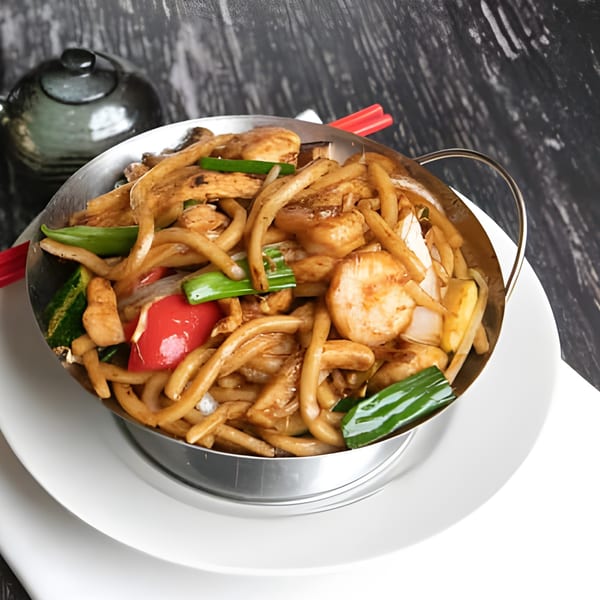 Asiana Cafe's stir-fried noodles with scallops, red peppers, and green onions in a metal bowl.